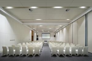an empty conference room with white chairs and a screen at Sanya Phoenix Airport Hotel in Sanya