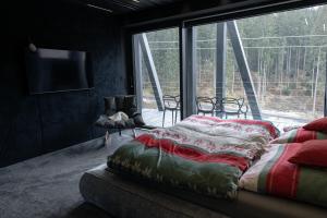 a bedroom with a bed and a large window at BÚDA Jasná in Demanovska Dolina