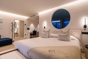a bedroom with a large white bed with a large mirror at Royal Marina Suites Boutique Hotel - Adults Only in Puerto Calero