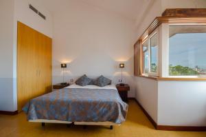 Hotel Principe Real في لشبونة: غرفة نوم بسرير ونافذة كبيرة