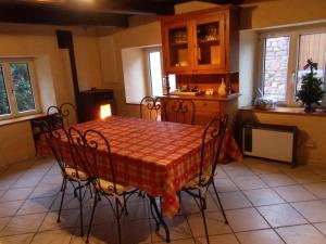 a dining room with a table and chairs in a kitchen at la roseraie in Fréland