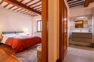 a bedroom with a bed and a bathroom with a sink at L'Olivazzo Apartment in Chiusi