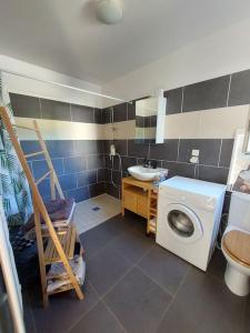 a bathroom with a washing machine and a sink at Namastĕ in Sisco +12 photos