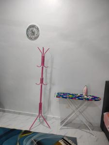 瓜拉丁加奴MAA Roomstay B的房间里有一张桌子，墙上挂着一个钟