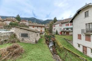 Blick auf ein Dorf mit Gebäuden und einem Bach in der Unterkunft Maison jacuzzi-sauna Station 7 Laux in Theys