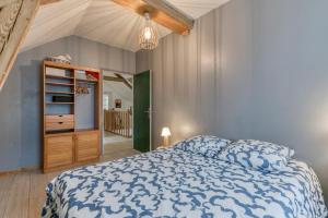 ein Schlafzimmer mit einem Bett mit einer blau-weißen Bettdecke in der Unterkunft Maison jacuzzi-sauna Station 7 Laux in Theys