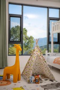 una camera da letto per bambini con tenda e giocattoli di fronte a una finestra di Tonglu HECHU Laf a Shanyinling