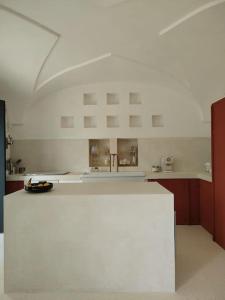 a white kitchen with a sink and a counter at Casa Lama in Monopoli