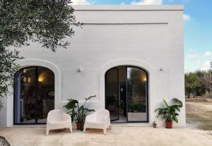 two white chairs in front of a white building at Casa Lama in Monopoli