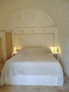 a bedroom with a white bed with two night stands at Casa Lama in Monopoli