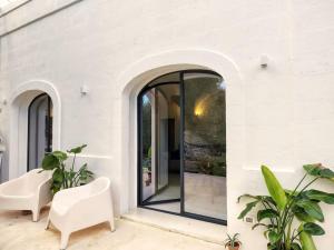 a white house with glass doors and white chairs at Casa Lama in Monopoli +12 photos
