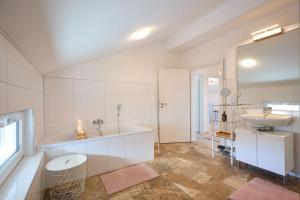 a bathroom with a sink and a tub and a toilet at Ferienwohnung zum Hochgarten in Krün