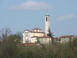 a large white building with a clock tower on a hill at BeB Orio in Capriate San Gervasio