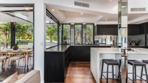 an open kitchen and dining room with a table and chairs at Sandcastles in Casuarina