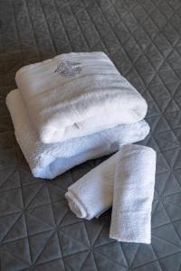two white towels sitting on top of a bed at Glyfada center seaview B in Athens