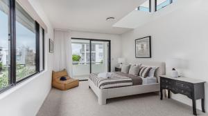 a white bedroom with a bed and a window at Sandcastles in Casuarina +61 photos