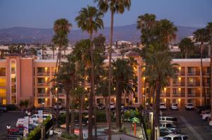a parking lot with palm trees in front of a building at Grand Legacy At The Park in Anaheim