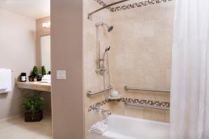 a bathroom with a shower with a tub at Grand Legacy At The Park in Anaheim