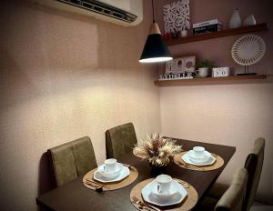 a dining room with a table and chairs with plates and bowls at Lydelles Guesthouse in Butuan +14 photos
