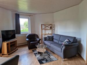 a living room with a couch and a tv at Ferienwohnung Esther in Naila
