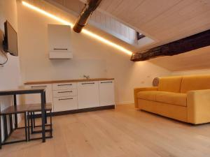 a living room with a yellow couch and a table at Downtown Roof in Como