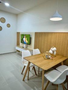 a dining room with a wooden table and white chairs at The Shore Suite seaview balcony Free Wifi & Netflix in Kota Kinabalu