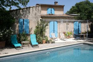 a house with chairs and a swimming pool at jolie location, maison avec piscine et joli jardin fleuri, à oppède dans le luberon en provence – 6 personnes in Oppède