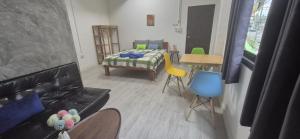 a living room with a bed and a table and chairs at Colibri Inn in Thong Sala