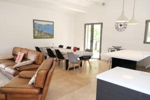 a living room with a couch and a table at charming vacation rental with heated pool at the foot of the alpilles, in aureille, close to the center of the village on foot, sleeps 6/8 people in provence. in Aureille