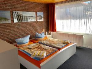 a large bed in a room with a brick wall at Ferienwohnung Haus Rügen auf Borkum in Borkum