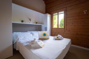 a bedroom with a bed with white sheets and a window at Club del Sole Adriano Family Collection in Punta Marina +149 photos