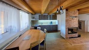 a kitchen and dining room with a wooden table at Chata Jožka in Vyšné Ružbachy