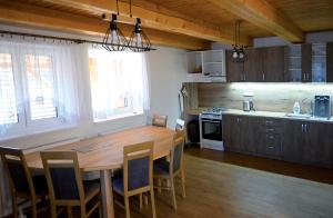 a kitchen with a large wooden table and chairs at Chata Jožka in Vyšné Ružbachy +11 photos