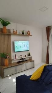 a living room with a flat screen tv on a wall at Temporada Imbassaí Ba in Matta de São João +19 photos