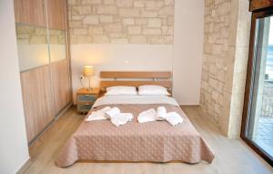 una camera da letto con un letto con asciugamani sopra di Petrina Villa A a Kastrí