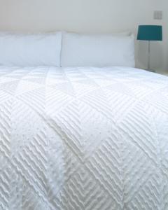 a white bed with white sheets and pillows at Oak Lodge in Welling