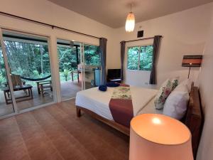 a bedroom with a bed and a sliding glass door at Zabit Bungalow in Ko Lanta