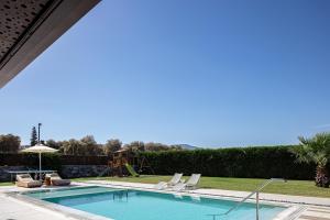 basen z leżakami i placem zabaw w obiekcie Terrazzo Luxury Villas w mieście Pigianos Kampos
