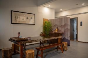 a room with a table and some wooden stools at Riverside Inn HANGZHOU in Hangzhou