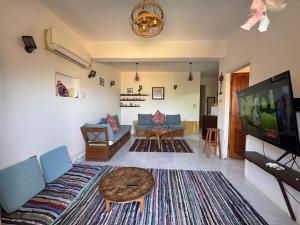 a living room with a couch and a flat screen tv at Luna House Asala Beach - Chalet in Dahab