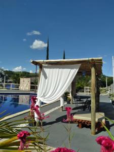 un patio con baldacchino bianco accanto alla piscina di Rancho Thellys a Luziânia