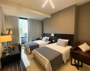 a hotel room with two beds and a window at 365 UrbanLiving in Jbeil