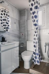 a bathroom with a toilet and a shower curtain at Christinas apartment in Nea Moudania +37 photos