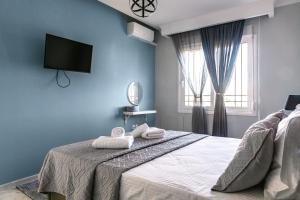 a blue bedroom with a bed with towels on it at Christinas apartment in Nea Moudania