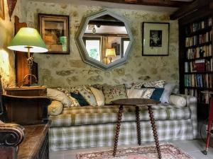 a living room with a couch and a mirror at Maison confortable à Bréhémont avec jardin paisible in Bréhémont