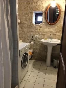 a bathroom with a washing machine and a sink at Maison confortable à Bréhémont avec jardin paisible in Bréhémont