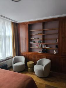 a bedroom with two chairs and a book shelf at Blue Wave Stay - Free Parking in Scheveningen