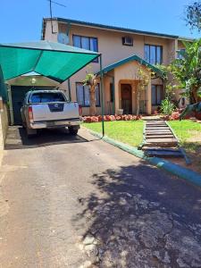 a truck parked in front of a house with a green roof at Rubie's self-catering home in Durban