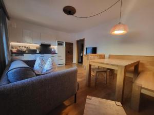 a living room with a couch and a wooden table at Appartements Krautgasser in San Candido