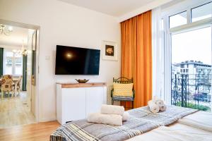 a bedroom with a bed with a flat screen tv at Prince Apartment by Baltic Home in Świnoujście